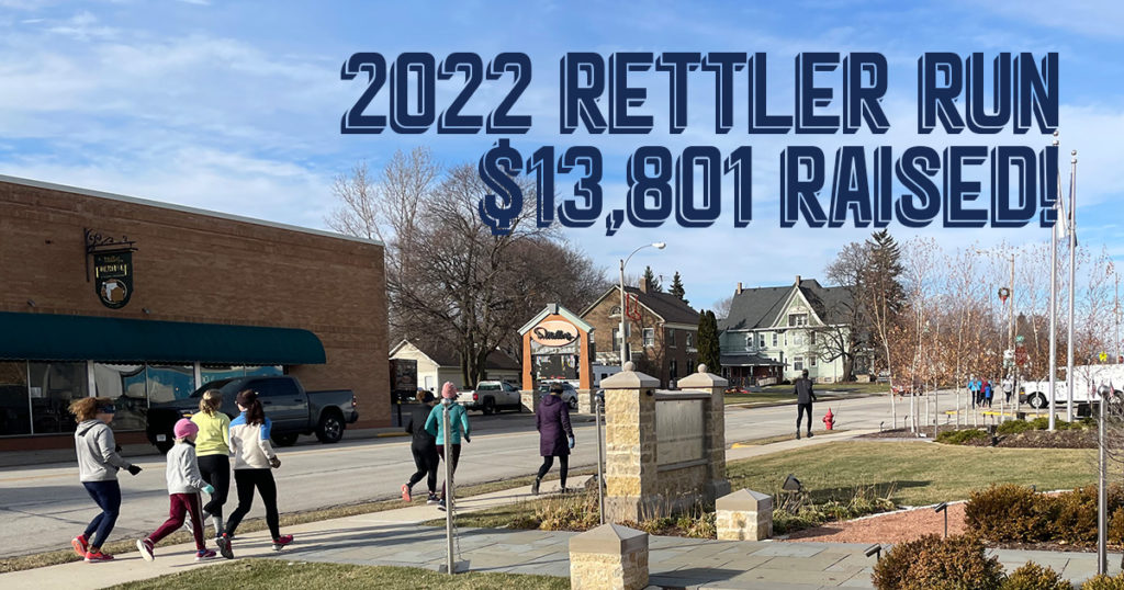 People running down Fond du Lac Ave in Kewaskum with the words "2022 Rettler Run. $13,801 Raised!"