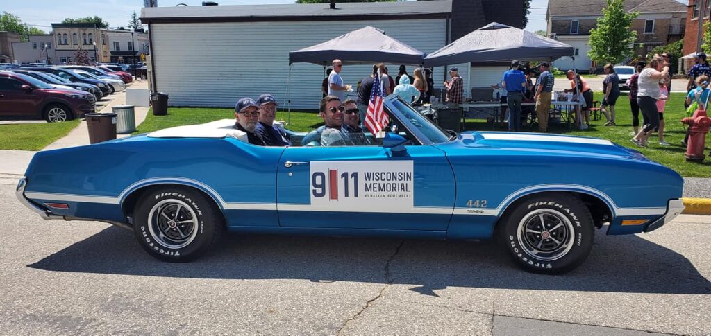 Gordon Haberman and Tom Fabitz in the back of a convertible at the Memorial.
