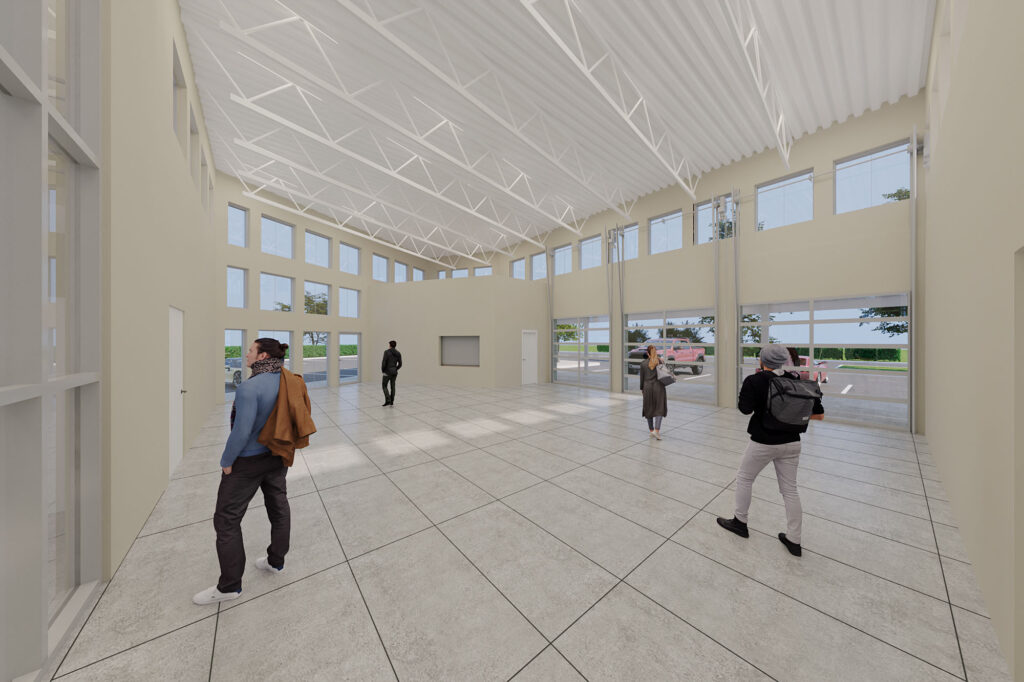Rendering of the community room interior, featuring high ceilings, wide tile flooring, and tall windows allowing in ample daylight. Several people walk through the versatile open space.