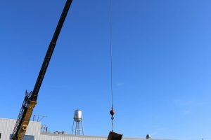 Crane lowering the beam into place